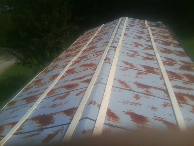Rusted metal roof panels with new wood purlins before replacement — Storm Damage Roof Repair in Northfield by Roofing Brothers